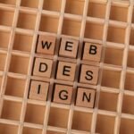 Wooden blocks spelling web design on a grid background symbolizing creative digital design concepts.